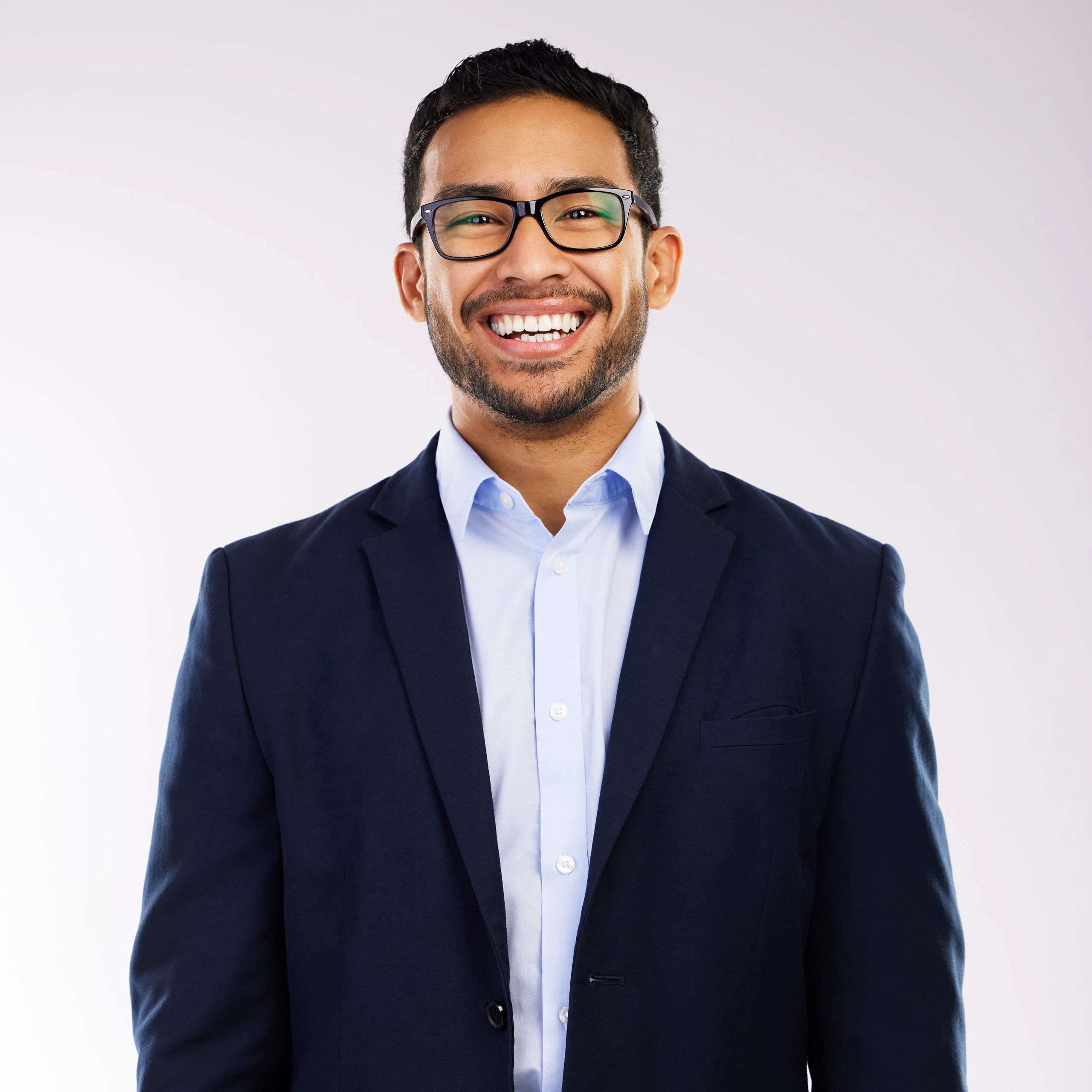 Professional headshot of a smiling man on a gray background