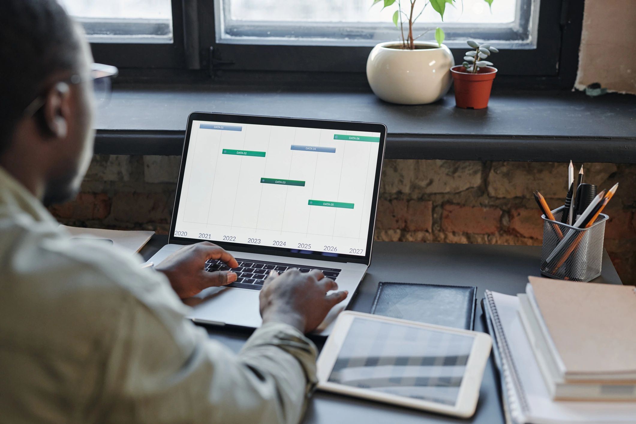Marketer working at a desk with laptop and analytics on screen