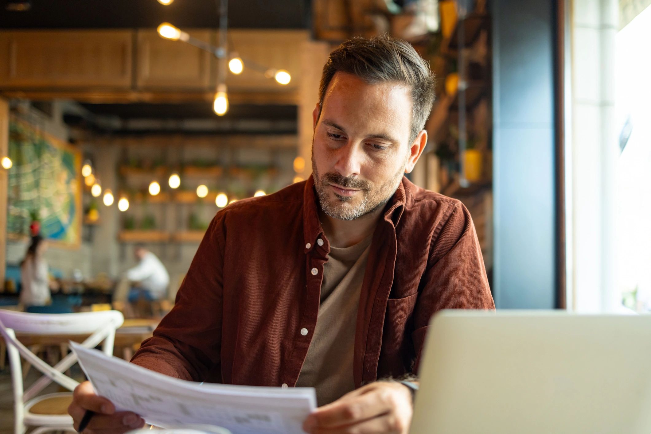 Founder reviewing a report with a laptop and coffee